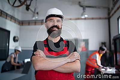 Portrait of worker with helmet indoors in factory looking at camera. Stock Photo