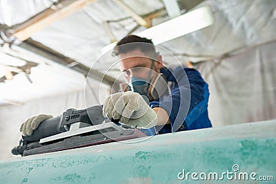 Man Polishing Boats in Workshop Stock Photo