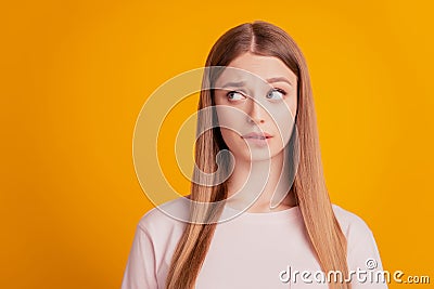 Portrait of worried troubled lady bite lip look side empty space think on yellow background Stock Photo