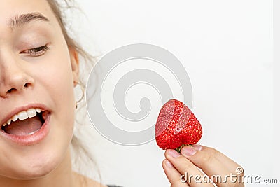 Portrait of yaung woman eating strawberries. Stock Photo