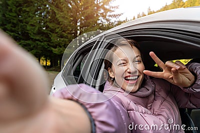Portrait of young adult beautiful caucasian woman driver enjoy roadtrip adventure traveling by car on mountain nature Stock Photo