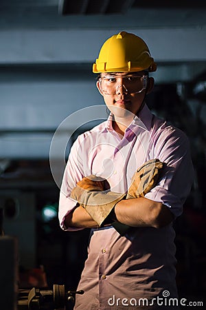 Portrait of young adult experienced industrial asian worker over industry machinery Stock Photo