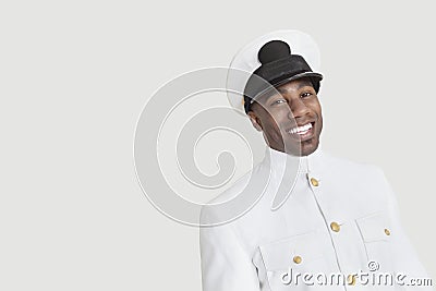 Portrait of a young African American US Navy officer smiling over gray background Stock Photo