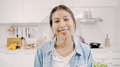 Portrait of young Asian Latin woman feeling happy smiling at home. Hispanic girl relax toothy smile looking to camera in kitchen Stock Photo