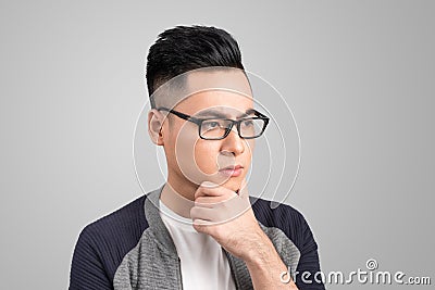 A portrait of a young asian man thinking looking down o Stock Photo