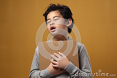 Portrait of young Asian student boy tired slept and yawning when reading a book, student tired when studying hard Stock Photo