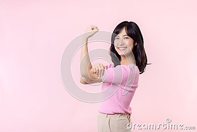 Portrait young asian woman proud and confident showing strong muscle strength arms flexed posing, feels about her success Stock Photo