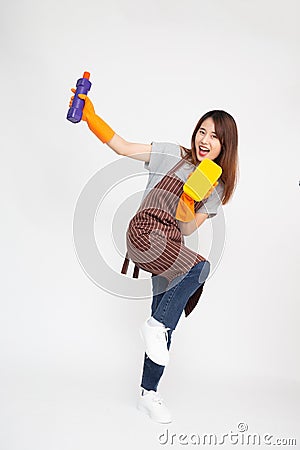 Asian woman wearing orange rubber gloves for hands protection and holding cleaning products and yellow sponge Stock Photo
