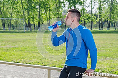 Portrait of a young athlete in headphones drinking water Stock Photo