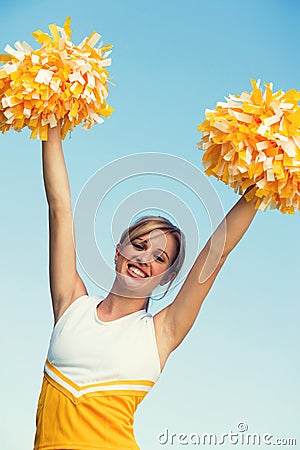 Portrait of young attractive cheerleader with pom poms Stock Photo