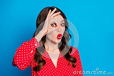 Portrait of young attractive funky playful comic woman showing okay sign on eye pout lips isolated on blue color Stock Photo