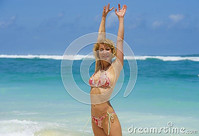 Portrait of young attractive and happy woman in bikini posing at amazing beautiful desert beach raising arms free enjoying Summe Stock Photo
