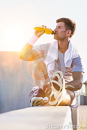 Portrait of young attractive man sitting while drinking energy drink Stock Photo