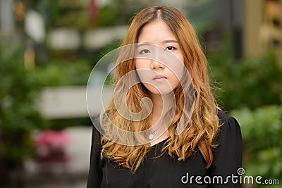 Face of young beautiful Asian businesswoman at the park Stock Photo