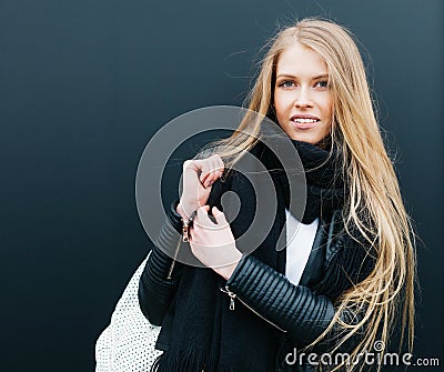 Portrait of a young beautiful blonde girl nex to black background. Spring, young, beauty. Outdoor. Warm color. Stock Photo