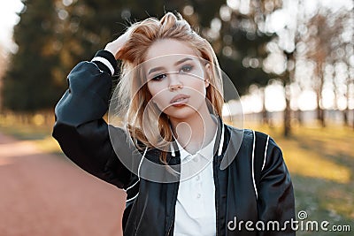 Portrait of a young beautiful blonde woman in a fashionable light black jacket in a stylish white shirt Stock Photo