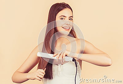 Portrait of young beautiful girl using styler on her shining hair Stock Photo