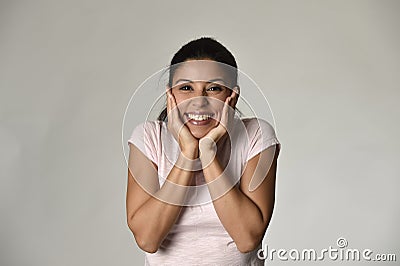 Portrait of young beautiful and happy Latin woman holding face with hands with big toothy smile Stock Photo