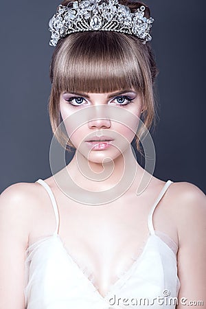 Portrait of young beautiful teenager girl with expressive blue eyes and full parted lips wearing crystal crown looking straight Stock Photo