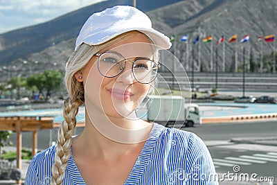 Portrait of a young beautiful woman, blonde in a cap, glasses and with a scythe. Stock Photo