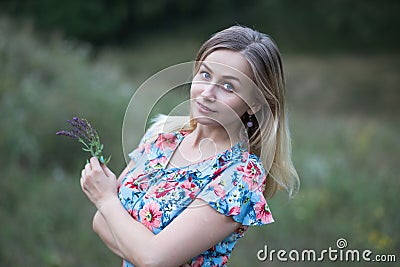 Portrait of young beautiful woman in flower vintage dress holding flowers in her hands Stock Photo