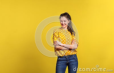 Portrait of a young beautiful woman in studio on yellow background. Stock Photo