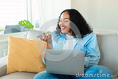 Portrait of young black chubby woman using laptop and talking on speakerphone, dictating voice message Stock Photo