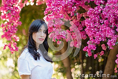 Happy beautiful young woman near blossom tree in garden. Stock Photo