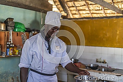 Portrait of young black male African chef cooking in the restaurant kitchen. Editorial Stock Photo