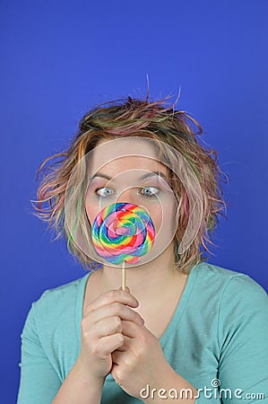 Young blond woman with big lollipop squinting Stock Photo