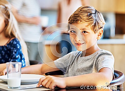 Breakfast is especially important for growing kids. Portrait of a young boy sitting at the breakfast table at home. Stock Photo