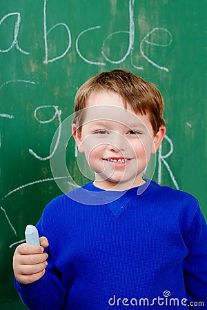 Portrait of young boy after writing on chalkboard Stock Photo