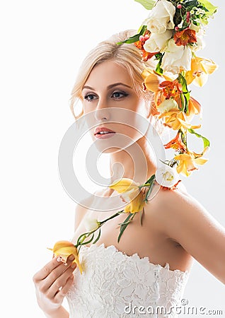 Portrait of a young bride in a white dress posing with flowers Stock Photo