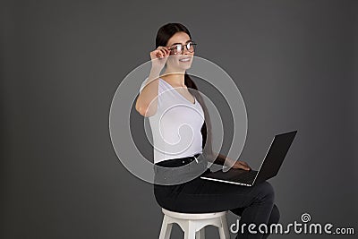 Portrait of young brunete woman in white t-shirt, dark jeans and glasses Stock Photo