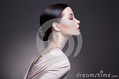 Portrait of young brunette woman against a dark background. Mysterious bright image of a woman with professional makeup Stock Photo