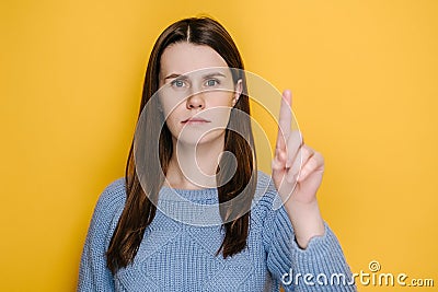 Portrait of young brunette woman warning with admonishing finger gesture, saying no, giving advice to avoid danger Stock Photo