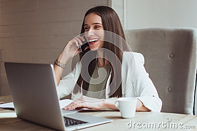 Portrait of a young businesswoman sitting with her laptop in the office Stock Photo