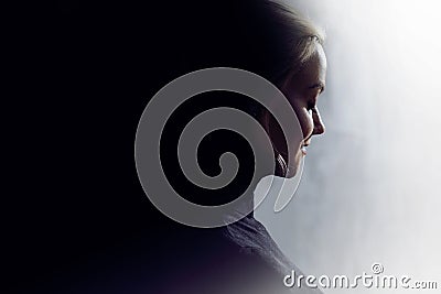 Portrait of a young calm woman in profile. Concept of the inner world and psychology, the dark and light side of personality. Stock Photo