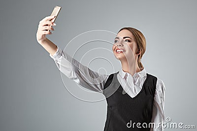 Portrait of young caucasian business woman in suit doing selfie on the phone. Stock Photo