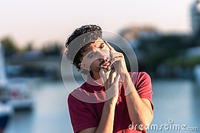 Young caucasian man with modern hair cut doing an effeminate gesture outdoors Stock Photo