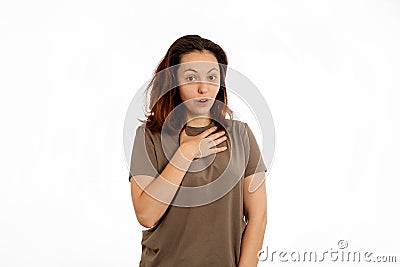 Portrait of a young Caucasian woman in surprise, putting her hand on her chest. White background. The concept of surprise Stock Photo