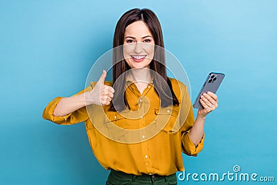 Portrait of young cheerful positive manager girl hold last iphone model fast speed wifi good interface thumb up isolated Stock Photo