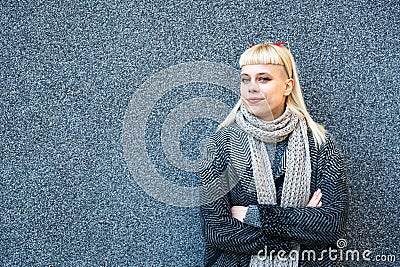 Portrait of young confident fashionable woman with cool attitude. Hipster stylish female posing against black wall Stock Photo