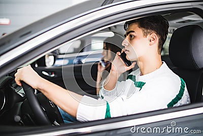 Portrait of a young couple speal phone and driving together, as seen through the windshield Stock Photo