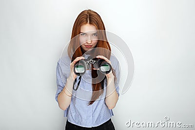 Portrait of young cute redhead woman wearing blue striped shirt smiling with happiness and joy while posing with binoculars again Stock Photo