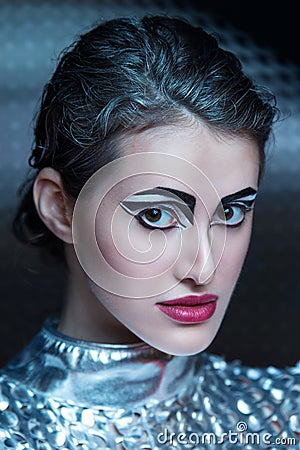 Portrait of young cyber woman in silver futuristic costume with bright makeup. Stock Photo