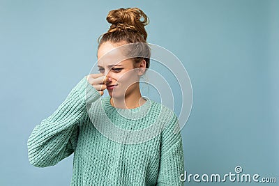 Portrait of young dissatisfied beautiful blonde woman with sincere emotions wearing casual blue pullover isolated on Stock Photo