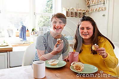 Portrait Of Young Downs Syndrome Couple Enjoying Tea And Cake In Kitchen At Home Stock Photo