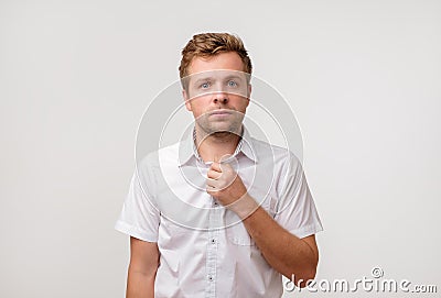 Portrait of young european man with sad face expression isolated on gray background Stock Photo