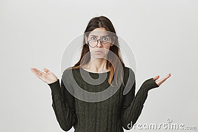 Portrait of young european student in dark-green sweater with confused and gloomy expression, wearing glasses and Stock Photo